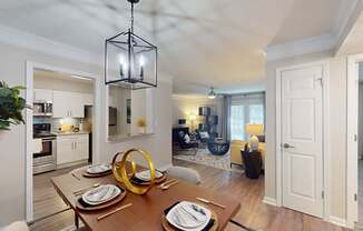 A dining room with a wooden table set for two.