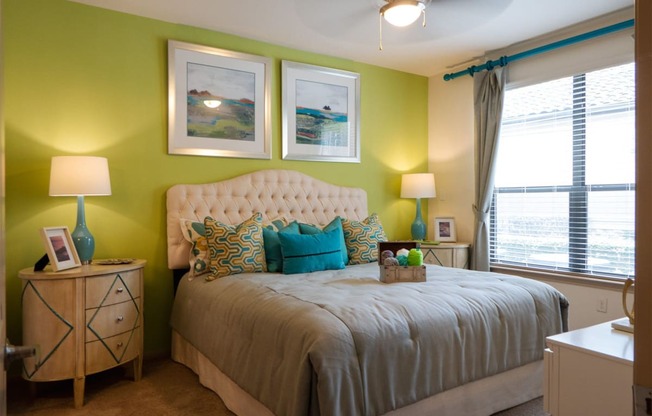 a bedroom with green walls and a bed with a white tufted headboard