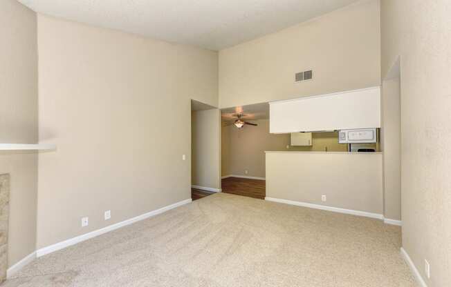 Empty Living room with Carpet, View of Kitchen and Ceiling Fan/Light