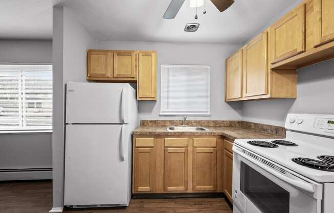 a kitchen with white appliances and wooden cabinets