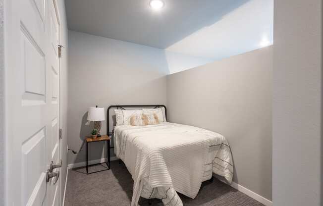 a bedroom with a small bed and a white closet