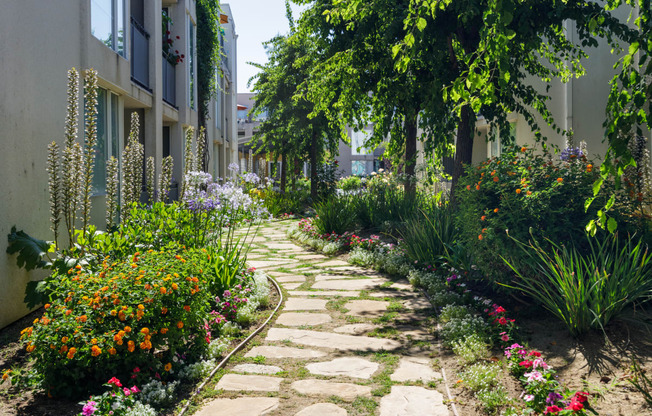 a stone path in a garden next to a building