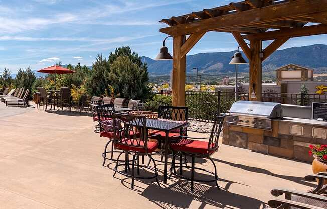 A patio with tables and chairs and a mountain in the background.