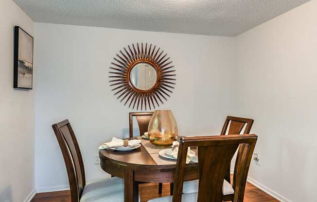 a dining room with a table and chairs and a mirror