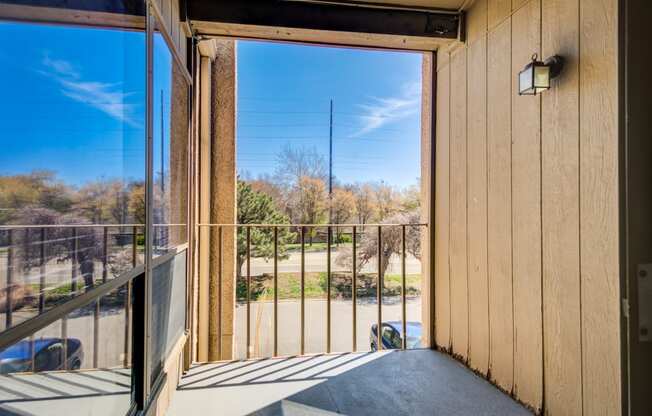 a balcony with a view of a yard and a glass door