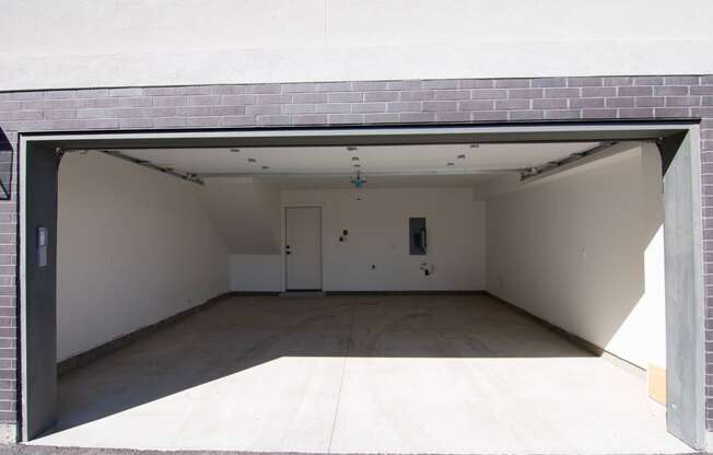 the inside of an empty garage with a door open