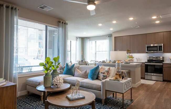 A modern living room with a sofa, coffee table, and kitchen area.