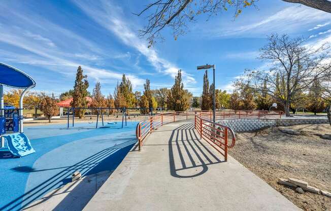 A playground with a blue slide and orange railings.