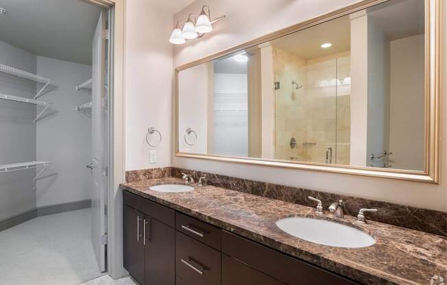 A bathroom with a marble countertop and a large mirror.