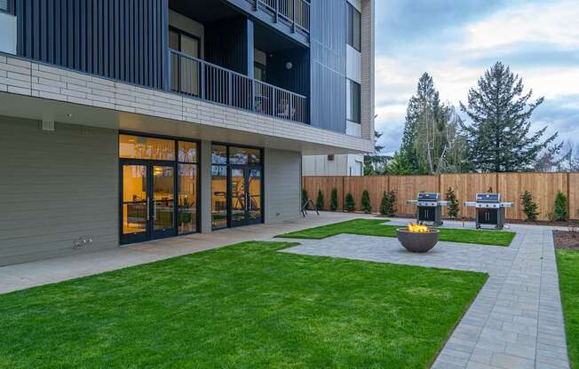 a backyard with a fire pit and a patio with two bbq pits