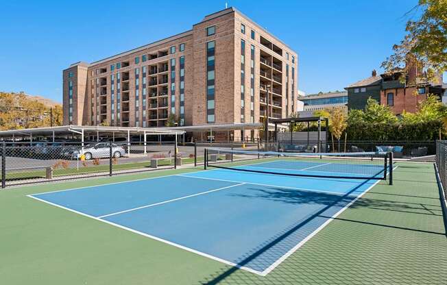 a tennis court with a building in the background