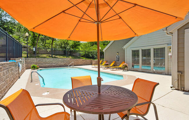 a patio with a pool and a table with an umbrella