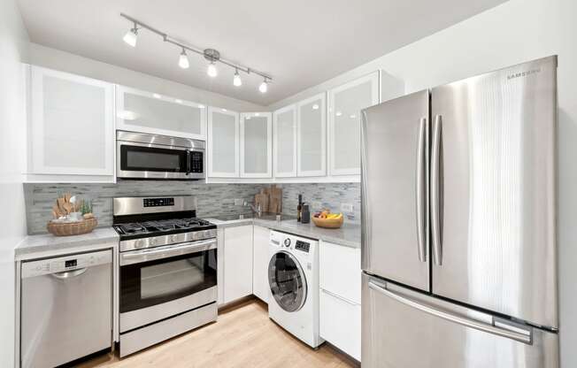 a kitchen with stainless steel appliances and white cabinets