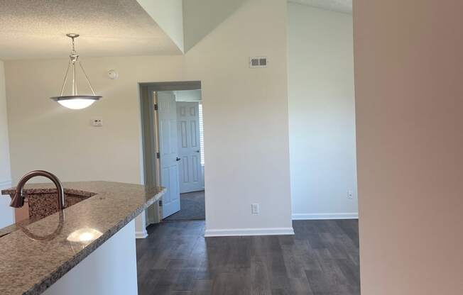 a view from the kitchen into the living room and hallway