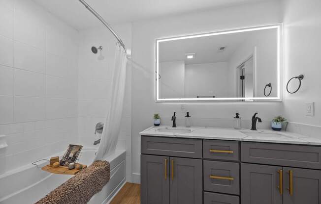 A bathroom with a white tub, sink, and mirror.