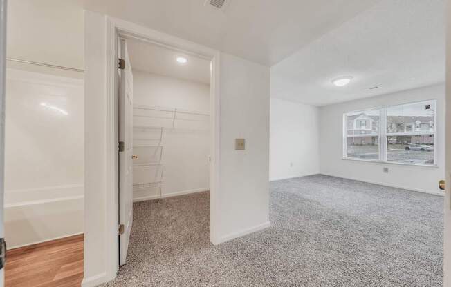 A room with a carpeted floor and a doorway leading to another room.