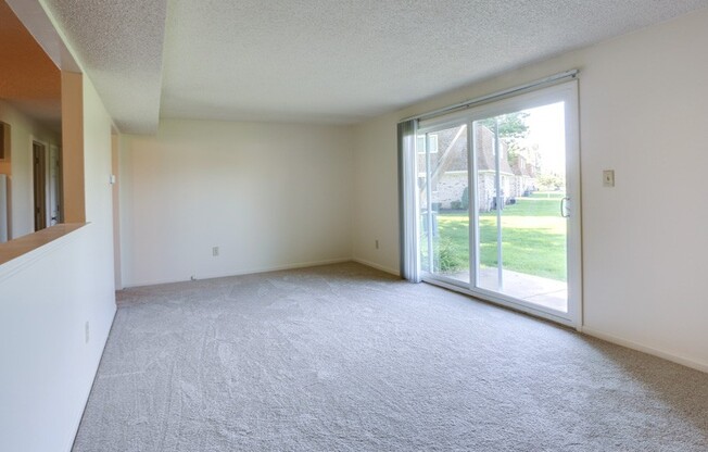 an empty living room with a sliding glass door