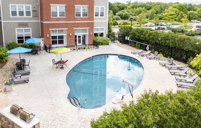 a swimming pool in a courtyard with a brick building