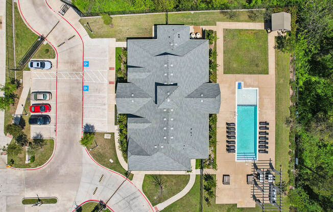 A large grey building with a pool in front of it.