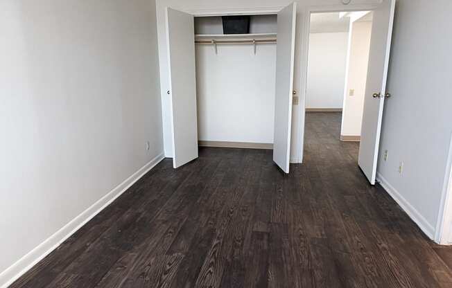 an empty living room with wooden floors and white walls