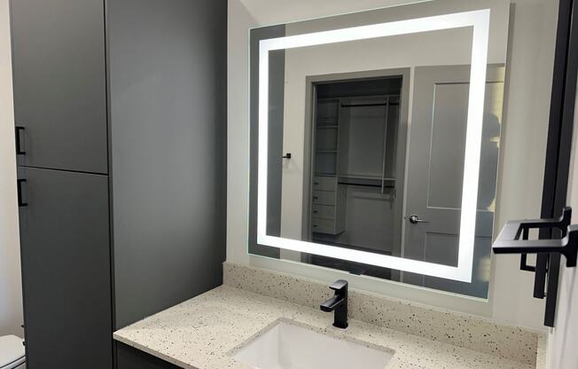 a bathroom with a sink and a mirror at The Depot, Raymore, MO, 64083