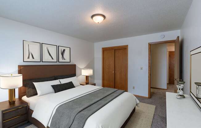 a bedroom with a large bed and a closet. Fargo, ND Schrock Apartments