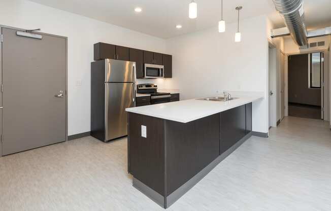 Modern open-concept kitchen and living area with stainless steel appliances.