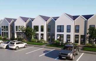 A row of houses with cars parked in front.