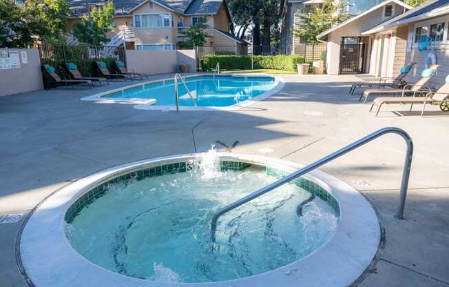 a hot tub in a pool in front of a house