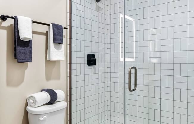 a white bathroom with a toilet and a shower