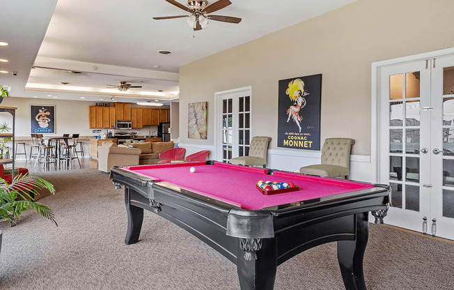 A pool table in a room with a ceiling fan.