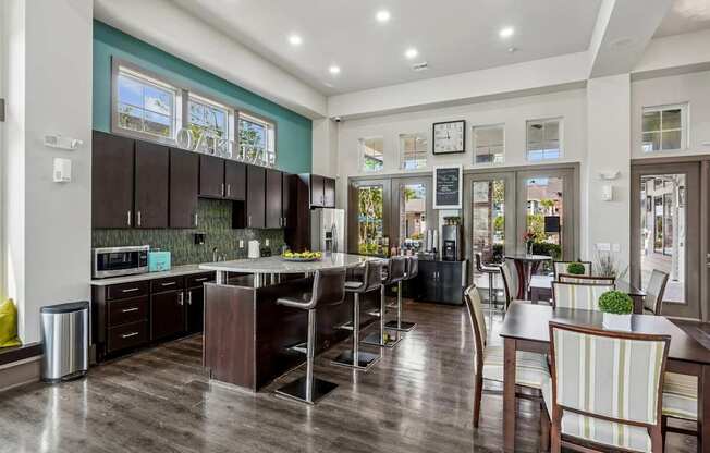 A modern kitchen with dark wood floors and a large island.