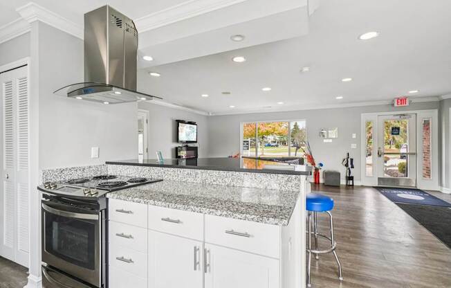 A modern kitchen with a granite countertop and stainless steel appliances.