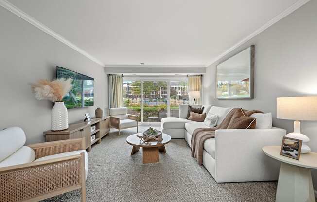 A well-lit, spacious living room with a variety of seating options and a coffee table.