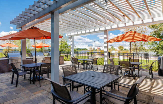 A patio with a table and chairs under a pergola.