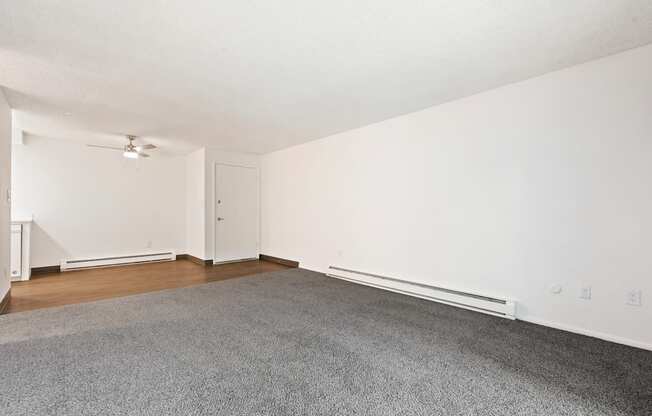 an empty living room with hardwood floors and white walls