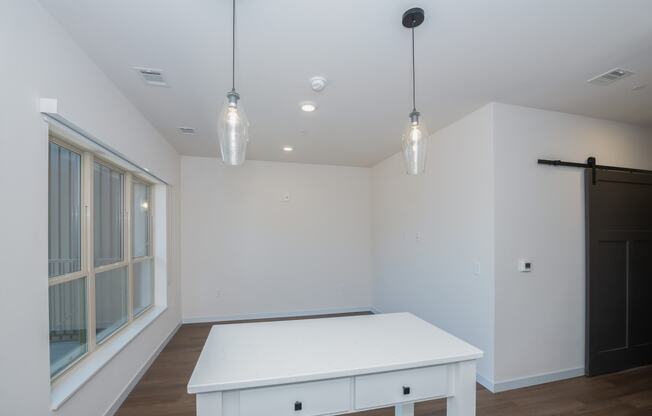 a dining room with a white table and a large window at The Crossings at Windsong, Prescott Valley, AZ