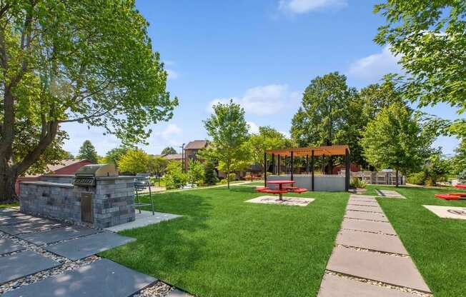 a large grassy area with a fire pit and picnic table