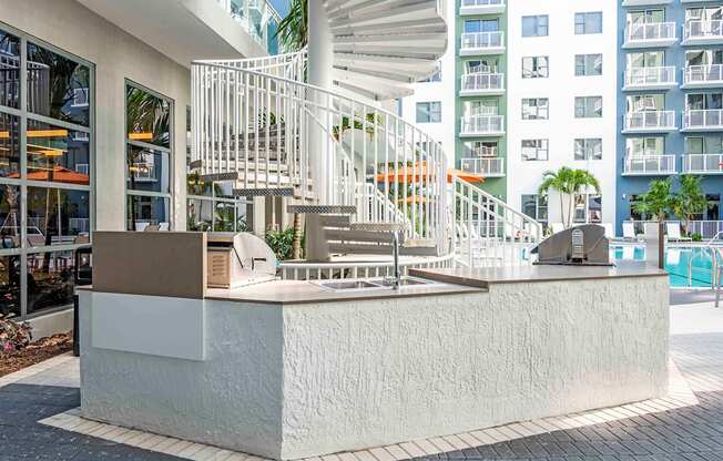 A white staircase with a metal railing is in front of a building.