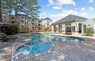 a swimming pool with an apartment building in the background