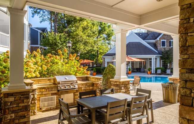 a patio with a table and chairs and a swimming pool