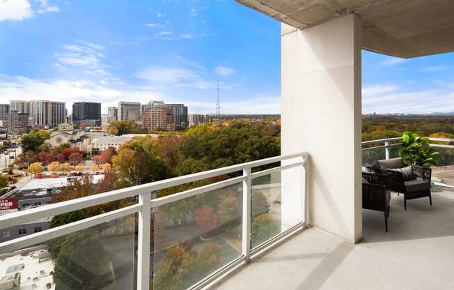 a balcony with a table and chairs and a view of the city