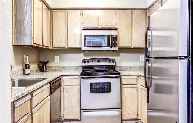 Stainless Steel microwave, dishwasher and refrigerator at Trinity Square Apartments For Rent in North Dallas, TX.
