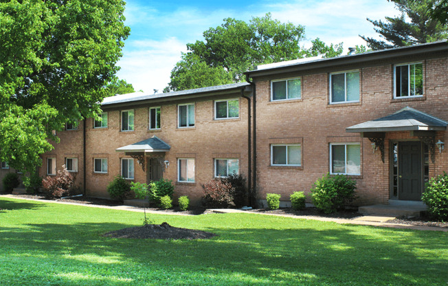 large brick apartment building with a lawn