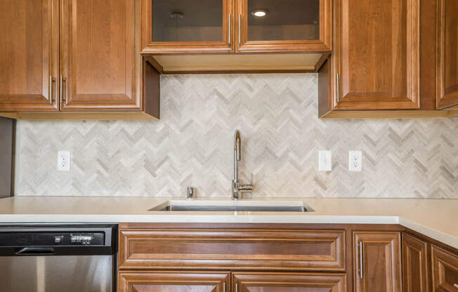 Ascend at Woodbury luxury apartment with herringbone backsplash in kitchen