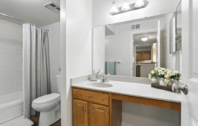 A white bathroom with a toilet, sink, and shower.
