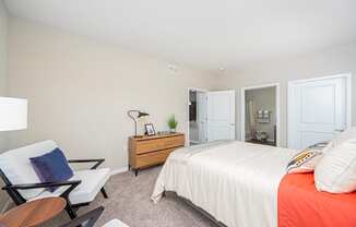 a bedroom with a bed and a chair and a closet