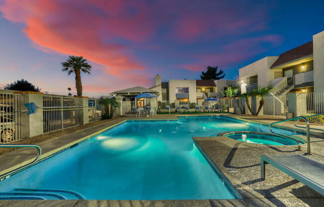 a swimming pool with a colorful sunset in the background