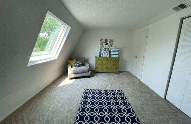 a living room with a carpet and a window