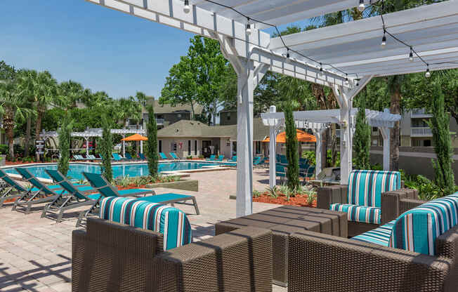 a pool with lounge chairs and umbrellas at a resort